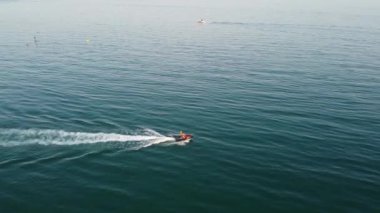 Bournemouth UK Beach ve Ocean 'daki Slow Motion High Angle Moving Sports Boat. Güzel Sıcak Yaz Günü. İnsanlar yaz tatilinin tadını çıkarıyor..