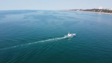 Bournemouth UK Beach ve Ocean 'daki Slow Motion High Angle Moving Sports Boat. Güzel Sıcak Yaz Günü. İnsanlar yaz tatilinin tadını çıkarıyor..