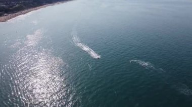 Bournemouth UK Beach ve Ocean 'daki Slow Motion High Angle Moving Sports Boat. Güzel Sıcak Yaz Günü. İnsanlar yaz tatilinin tadını çıkarıyor..