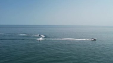 Bournemouth UK Beach ve Ocean 'daki Slow Motion High Angle Moving Sports Boat. Güzel Sıcak Yaz Günü. İnsanlar yaz tatilinin tadını çıkarıyor..