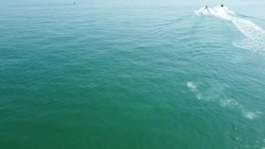 Bournemouth UK Beach ve Ocean 'daki Slow Motion High Angle Moving Sports Boat. Güzel Sıcak Yaz Günü. İnsanlar yaz tatilinin tadını çıkarıyor..