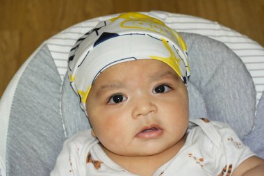 İngiltere 'nin Luton şehrindeki Home Garden' da keyif çatan şirin Asyalı Pakistanlı 4 aylık bebeğin yakın çekimi. Görüntü 23 Temmuz 2023 'te çekilmiştir.