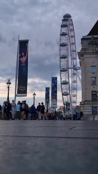 イギリスのセントラルロンドンシティのロンドンアイツーリストアトラクションで人々の低角度の映像が歩いています 映像は 2023年8月02日に撮影されました — ストック動画