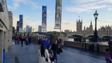 Londra Yolu boyunca yürüyen turistler Westminster Londra 'nın merkezi kenti İngiltere' de 22 Ağustos 2023 'te günbatımında yakalandılar..