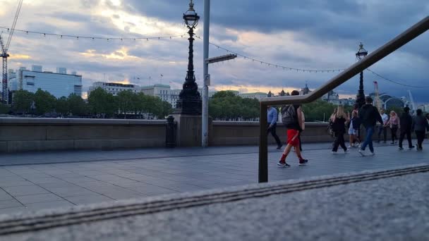 イギリスのウェストミンスター セントラル ロンドン シティでロンドン アイの道を歩く観光客 フッテージは 8月02日に撮影されました 2023 夕日中 — ストック動画