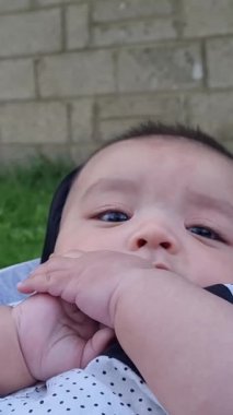 İngiltere 'nin Luton şehrindeki Home Garden' da keyif çatan şirin Asyalı Pakistanlı 4 aylık bebeğe yakın çekim. Görüntü 23 Temmuz 2023 'te çekildi.