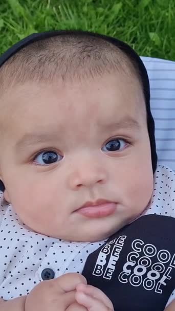 イギリスのルートン市のホームガーデンで楽しんでいる かわいいアジアのパキスタン人4ヶ月の赤ん坊の男の子のクローズアップ 映像は2023年7月23日に撮影されました — ストック動画