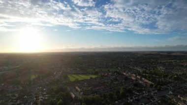 Gün batımında şehrin üzerinde hareket eden hızlandırılmış bulutlar