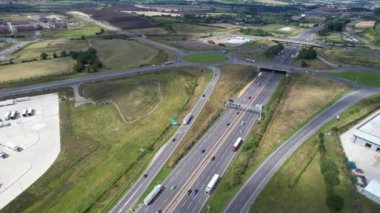 Bulutlu Öğleden Sonra Yoğun Trafikli İngiliz Otoyollarının Yüksek Açılı Görüntüleri. Görüntüler, İngiltere 'nin Luton şehrinde M1 kavşağında İHA' nın kamerasıyla 15 Ağustos 2023 'te çekildi.