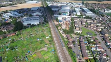 Luton şehrinden geçen ve İngiltere 'deki Luton Leagrave Tren İstasyonu' na yaklaşan trenin güzel hava görüntüleri. Görüntü İHA 'nın Kamerasıyla 15 Ağustos 2023' te çekildi.