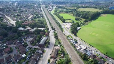 Luton şehrinden geçen ve İngiltere 'deki Luton Leagrave Tren İstasyonu' na yaklaşan trenin güzel hava görüntüleri. Görüntü İHA 'nın Kamerasıyla 15 Ağustos 2023' te çekildi.