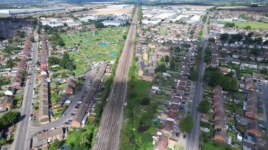 Luton şehrinden geçen ve İngiltere 'deki Luton Leagrave Tren İstasyonu' na yaklaşan trenin güzel hava görüntüleri. Görüntü İHA 'nın Kamerasıyla 15 Ağustos 2023' te çekildi.