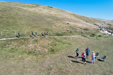 İngiltere 'nin Durdle Door Tepeleri' ndeki insanlar Büyük Britanya, İngiltere. Görüntü İHA 'nın kamerasıyla 9 Eylül 2023' te çekildi.