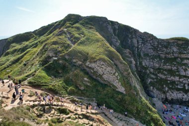 İngiltere 'nin Durdle Door Tepeleri' ndeki insanlar Büyük Britanya, İngiltere. Görüntü İHA 'nın kamerasıyla 9 Eylül 2023' te çekildi.