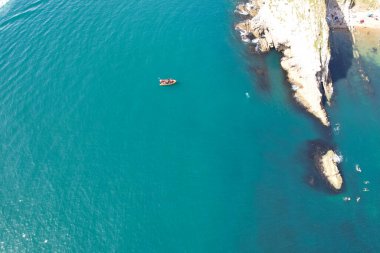Muhteşem Yüksek Açılı Halk Manzarası İngiltere 'nin Durdle Door Manzaralı Suları' nın Okyanus Sahili 'nde Britanya' nın Kayılarda ve Yüzmede Sıcak Havası 'nın tadını çıkarıyor. Resim 9 Eylül 2023 'te çekildi.