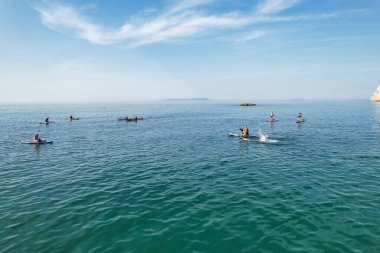 Muhteşem Yüksek Açılı Halk Manzarası İngiltere 'nin Durdle Door Manzaralı Suları' nın Okyanus Sahili 'nde Britanya' nın Kayılarda ve Yüzmede Sıcak Havası 'nın tadını çıkarıyor. Resim 9 Eylül 2023 'te çekildi.
