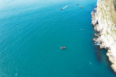 Muhteşem Yüksek Açılı Halk Manzarası İngiltere 'nin Durdle Door Manzaralı Suları' nın Okyanus Sahili 'nde Britanya' nın Kayılarda ve Yüzmede Sıcak Havası 'nın tadını çıkarıyor. Resim 9 Eylül 2023 'te çekildi.