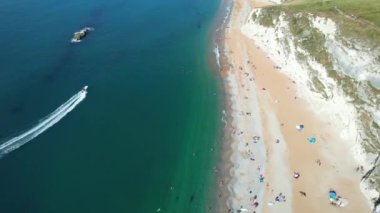 Muhteşem Yüksek Açılı Halk Manzarası İngiltere 'nin Durdle Door Manzaralı Suları' nın Okyanus Sahili 'nde Britanya' nın Kayılarda ve Yüzmede Sıcak Havası 'nın tadını çıkarıyor. 9 Eylül 2023 'te Çekilen Görüntü