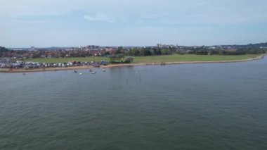 İngiltere 'nin Poole şehrinde okyanusun bir kısmıyla birlikte Sea Port ve Beach' teki Yüksek Sürat Teknelerinin Zaman Hızlandırılmış Hava Görüntüsü. Kamera 9 Eylül 2023 'te İHA' nın Kamerasıyla çekildi.