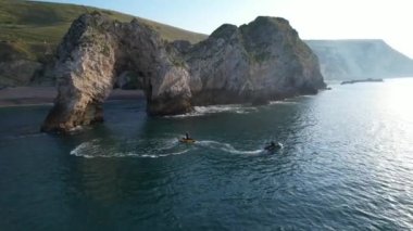 Muhteşem Yüksek Açılı Halk Manzarası İngiltere 'nin Durdle Door Manzaralı Suları' nın Okyanus Sahili 'nde Britanya' nın Kayılarda ve Yüzmede Sıcak Havası 'nın tadını çıkarıyor. 9 Eylül 2023 'te Çekilen Görüntüler