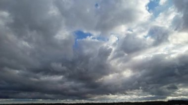 İngiltere 'nin Luton şehrinde hızlı hareket eden dramatik bulutların ve gökyüzünün yüksek açılı görüntüleri.