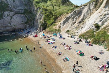 İnsanların Havadan Bakışı, Durdle Kapısı Doğal Sahili 'ndeki Sıcak Yaz Gününün tadını çıkarıyor. 9 Eylül 2023 'te, İngiltere' de Drone 'un Kamerasıyla Güzel Turist Çekimi