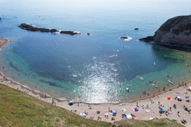 İnsanların Havadan Bakışı, Durdle Kapısı Doğal Sahili 'ndeki Sıcak Yaz Gününün tadını çıkarıyor. 9 Eylül 2023 'te, İngiltere' de Drone 'un Kamerasıyla Güzel Turist Çekimi