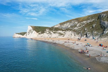 İnsanların Havadan Bakışı, Durdle Kapısı Doğal Sahili 'ndeki Sıcak Yaz Gününün tadını çıkarıyor. 9 Eylül 2023 'te, İngiltere' de Drone 'un Kamerasıyla Güzel Turist Çekimi