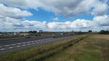 Bulutlu Öğleden Sonra Yoğun Trafikli İngiliz Otoyollarının Yüksek Açılı Görüntüleri. Görüntüler, İngiltere 'nin Luton şehrinde M1 kavşağında İHA' nın kamerasıyla 15 Ağustos 2023 'te çekildi.