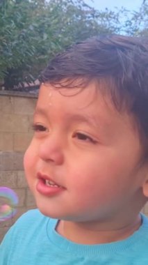 Şirin Asyalı Pakistanlı bebek İngiltere 'nin Luton şehrindeki Home' s Garden 'da baloncukların tadını çıkarıyor. 