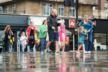 İngiltere 'nin merkez Luton şehrindeki insanlar Büyük Britanya üzerindeki güneşli bir günde. 22 Ağustos 2023 'te yakalandı.