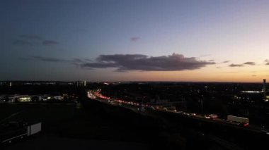 Günbatımından ve dolunaydan hemen sonra İngiltere 'nin Aydınlanmış Luton şehrinin en güzel yüksek açılı görüntüsü. Hava Görüntüleri İHA 'nın Kamerasıyla 17 Ekim 2024' te çekildi.