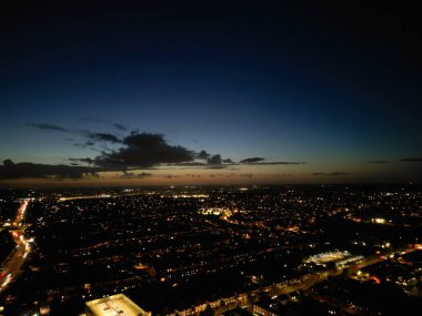 İngiltere 'nin Aydınlanmış Luton şehrinin en güzel yüksek açılı görüntüsü. Gün batımından hemen sonra ve dolunay gecesi. Hava Görüntüleri İHA 'nın Kamerasıyla 17 Ekim 2024' te çekildi.