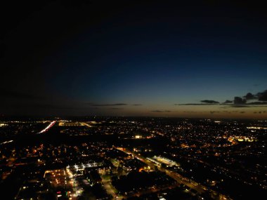 İngiltere 'nin Aydınlanmış Luton şehrinin en güzel yüksek açılı görüntüsü. Gün batımından hemen sonra ve dolunay gecesi. Hava Görüntüleri İHA 'nın Kamerasıyla 17 Ekim 2024' te çekildi.
