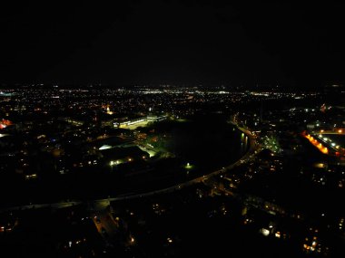 İngiltere 'nin Cambridgeshire şehrinin aydınlanmış hava görüntüsü. Gece boyunca. 22 Mart 2024 'te günbatımından hemen sonra İHA' nın Kamerasıyla Yüksek Açı Görüntüsü çekildi.