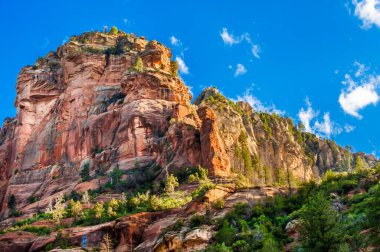Dağlar, kayalar ve güzel mavi gökyüzü ile nefes kesici doğa sahnesi.