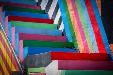 A high-angle perspective of an outdoor staircase with stripes in multiple colors creating a striking visual clipart