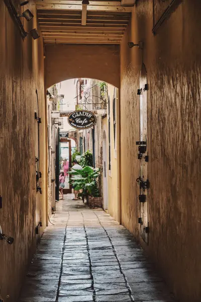 stock image A picturesque alley leading to a cozy restaurant with warm lighting and a welcoming sign at the end