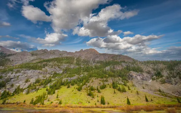Colorado 'nun yemyeşil sıradağlarının geniş manzarası, kalbin nefes kesici doğasını ve dinamik bir gökyüzü altında yükselen dağları gözler önüne seriyor.