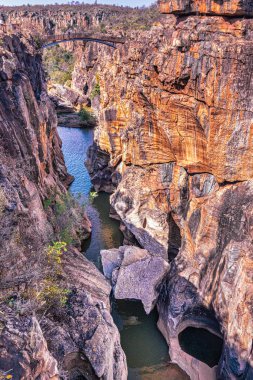 Doğal bir köprüsü ve nehri olan Rocky Kanyonu manzarası, dokulu kaya oluşumları ve sakin su elementleri sergiliyor..