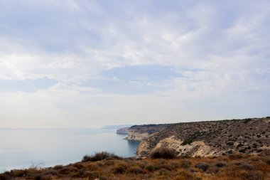 Büyük kayalar ve deniz kenarındaki küçük köyün manzarası.