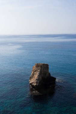 Kıbrıs 'ta kristal berrak mavi denize sahip tek bir kaya manzarası