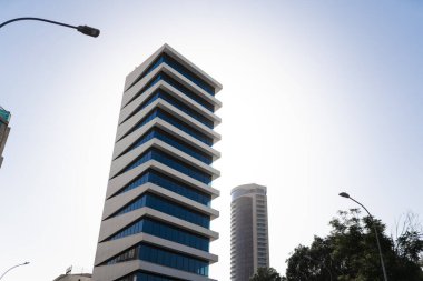 Çağdaş spiral yüksek binaların büyüleyici görüntüsü, canlı mavi gökyüzü zıt mimari tarzları sergiliyor.