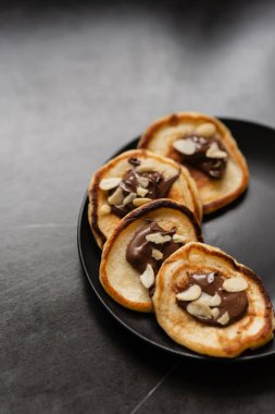 Kiraz reçeli ve kivi parçalarıyla damlayan bir tabak krep. Krep günü.