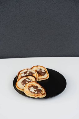 Kiraz reçeli ve kivi parçalarıyla damlayan bir tabak krep. Krep günü.