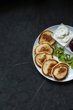 Plate of pancakes dripping with cherry jam, with kiwi pieces. Pancake day clipart