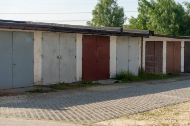 Polonya 'nın Suszec köyünde renkli metal kapıları olan eski garajlar.