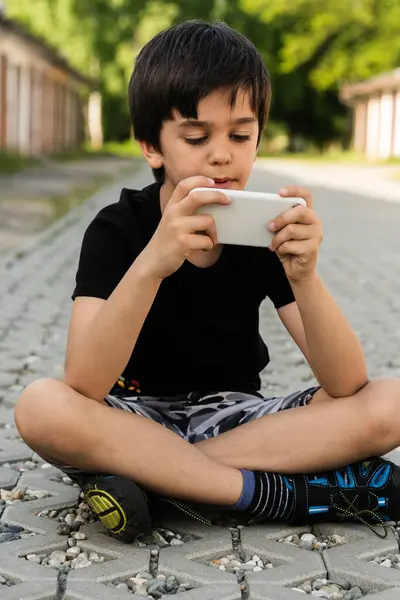 10 yaşında bir çocuk elinde bir akıllı telefon tutuyor, arkadaşlarıyla sohbet ediyor, video izliyor, sosyal ağlarda sörf yapıyor. Çocuk, dışarıda telefonu olan bir genç..