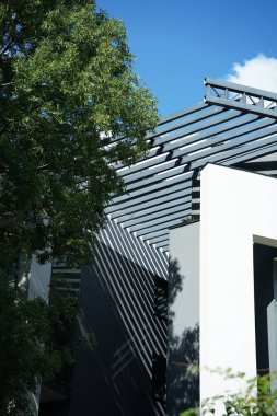 Bej duvarları ve demiryolu güneş ışığı gölgeleri olan modern doğu tarzı bir bina. Soyut mimari ön cephe tasarım kavramı