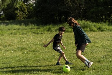 Çocuk futbol oynuyor. Çocuklar dışarıda futbol oynarlar. Küçük çocuk yaz parkında topa vuruyor. Küçük çocuklar için sağlıklı bir aktivite. Okul spor kulübü takımı. Futbol Küçükler Ligi.